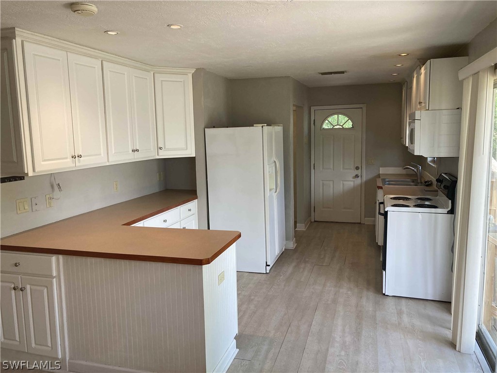 8429 Cardinal Road Fort Myers, FL 33967 - Photo 4 of 16 a kitchen with stainless steel appliances granite countertop a refrigerator sink and white cabinets