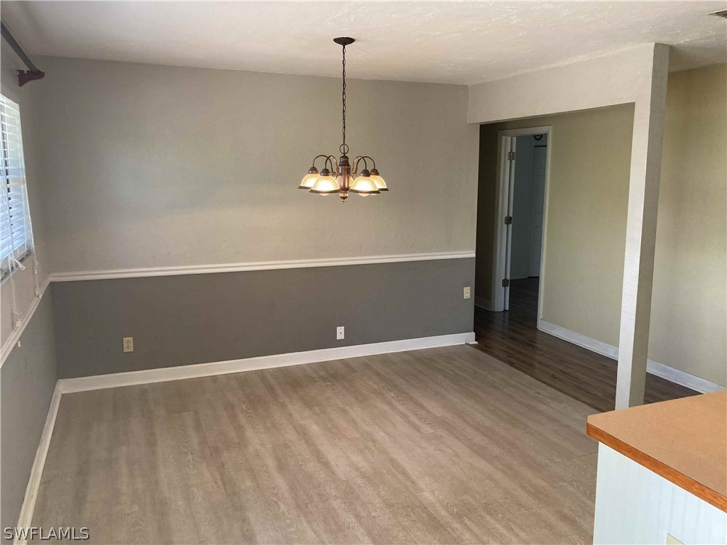 8429 Cardinal Road Fort Myers, FL 33967 - Photo 5 of 16 a view of a livingroom with wooden floor and a chandelier
