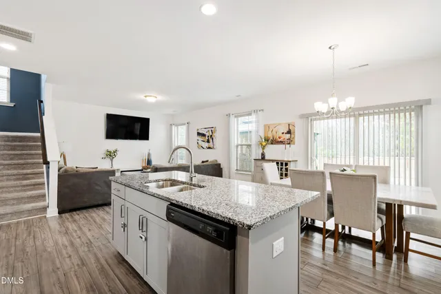 a open kitchen with granite countertop a sink dining table and chairs