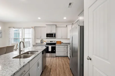 a kitchen with stainless steel appliances granite countertop a sink stove and refrigerator
