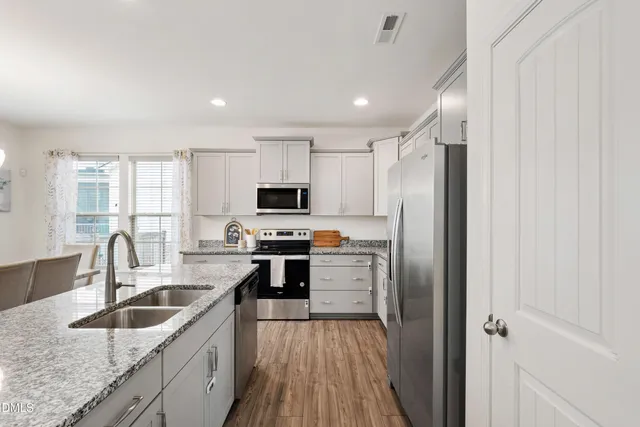 a kitchen with stainless steel appliances granite countertop a sink stove and refrigerator