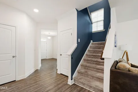 a view of a livingroom with wooden floor and stairs