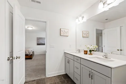 a en suite bathroom with a sink double vanity and a mirror