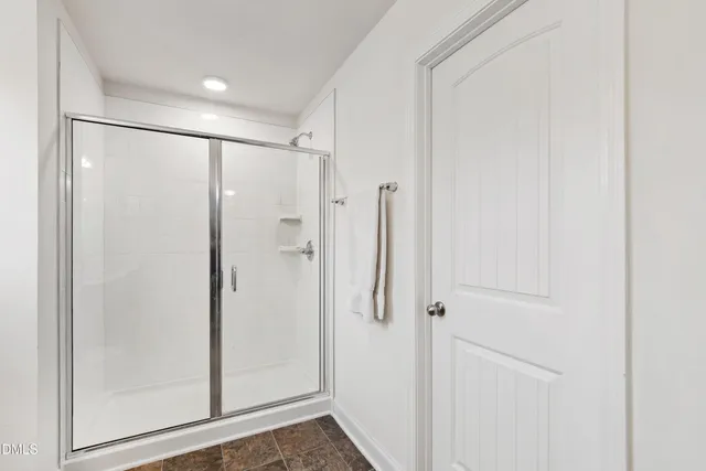 a bathroom with a shower and a glass door