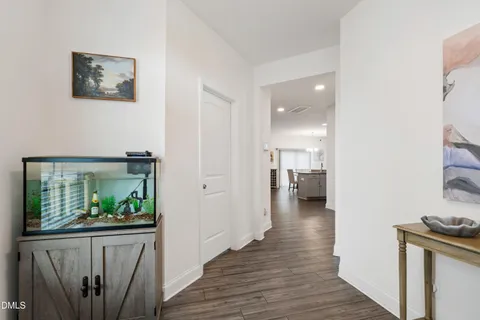 a view of a hallway with wooden floor and furniture