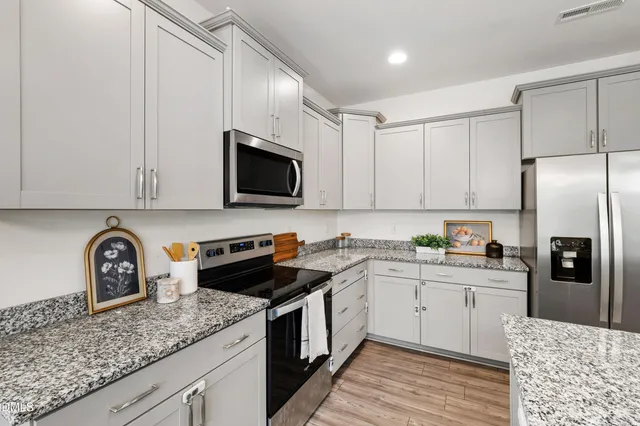 a kitchen with stainless steel appliances granite countertop a sink stove and refrigerator