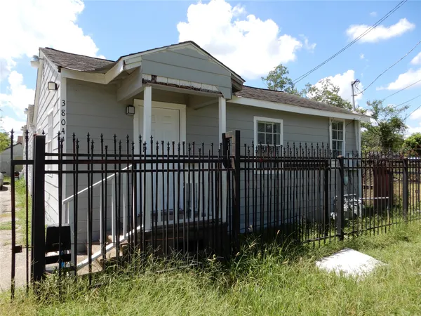 a view of a house with wooden fence
