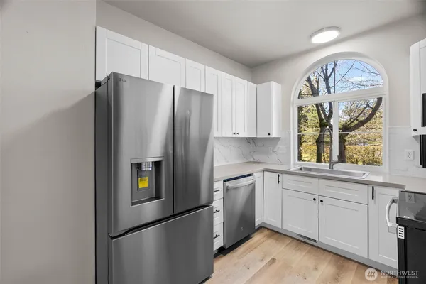 a kitchen with stainless steel appliances granite countertop a refrigerator and a sink