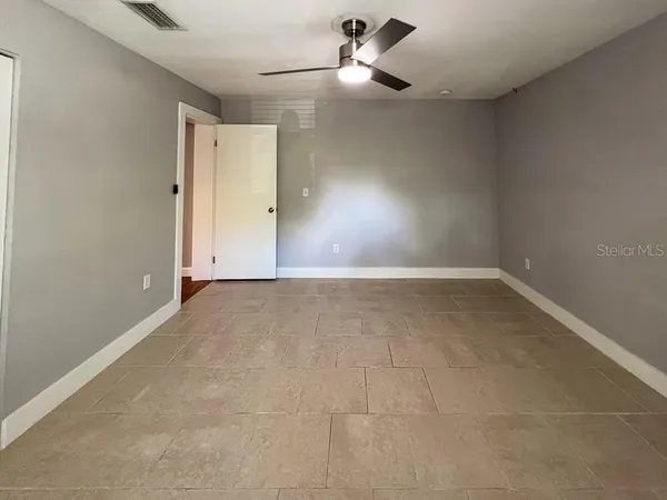 an empty room with a ceiling fan and carpet