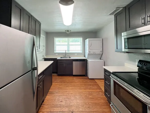 a kitchen with granite countertop a refrigerator and a stove top oven