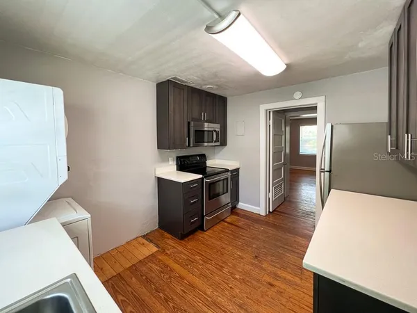 a kitchen with a refrigerator and a stove top oven