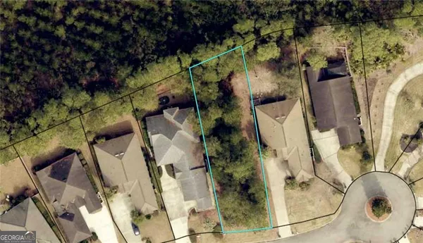 an aerial view of a house with a yard and large trees