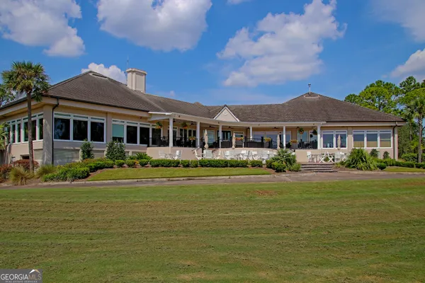 a front view of a house with a garden and lake view