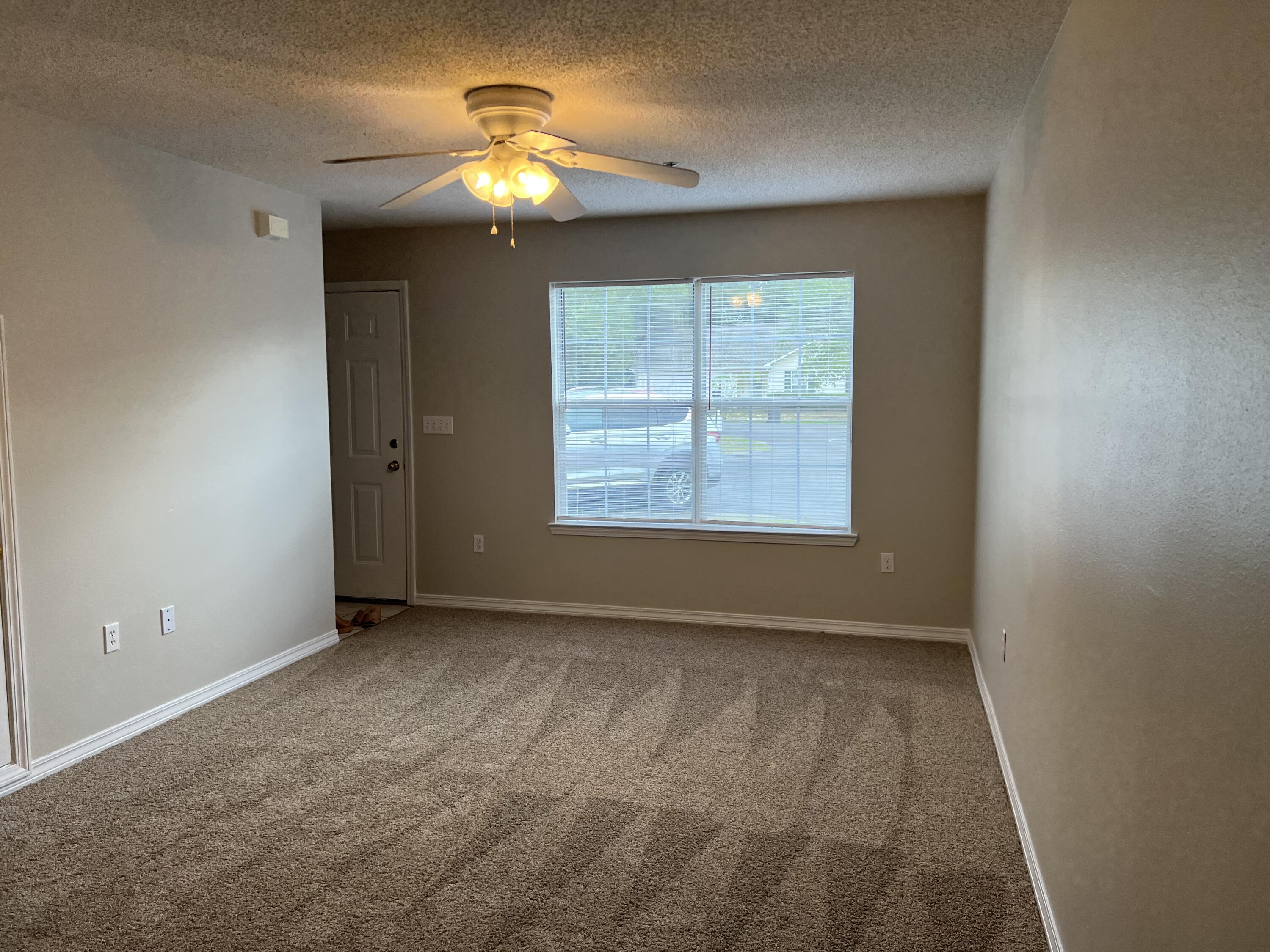 224 Runnymeade Drive Crestview, FL 32539 - Photo 4 of 11 an empty room with windows and chandelier fan