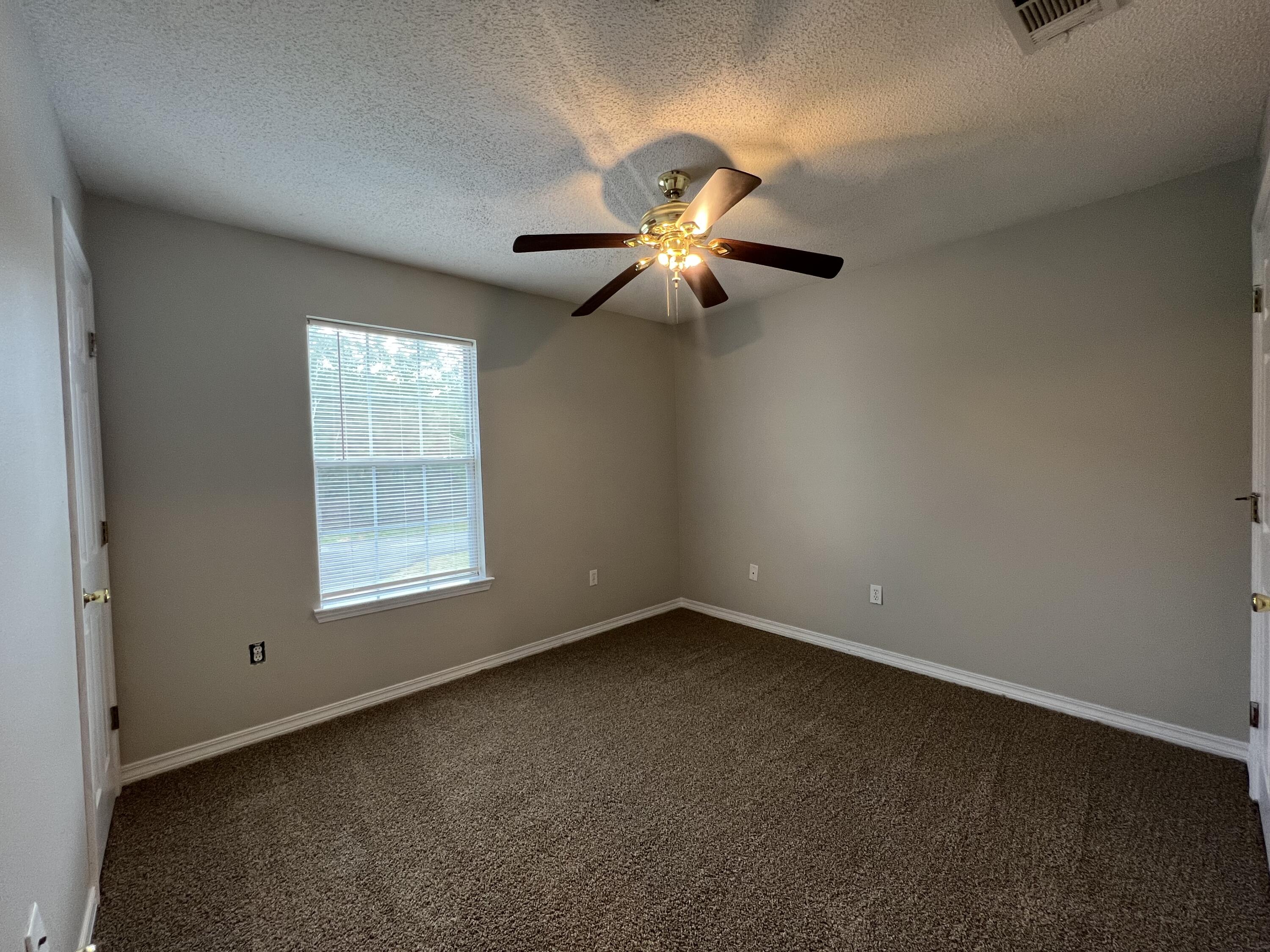224 Runnymeade Drive Crestview, FL 32539 - Photo 8 of 11 an empty room with a window and a fan
