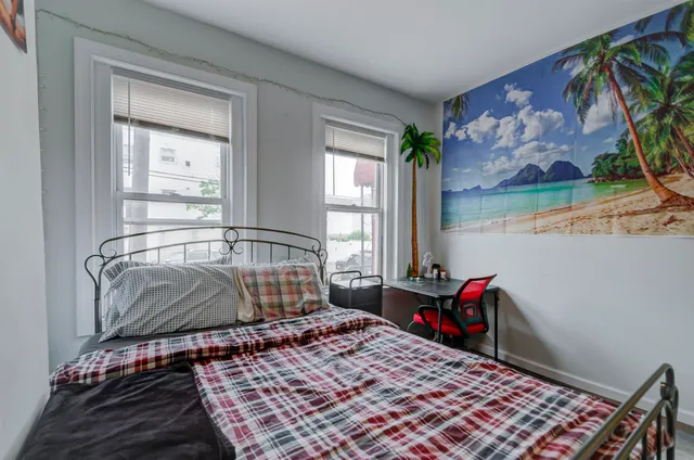 a bedroom with a bed and painting on the wall