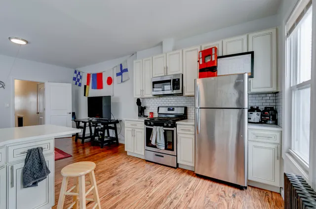 a kitchen with stainless steel appliances granite countertop a refrigerator and a stove top oven
