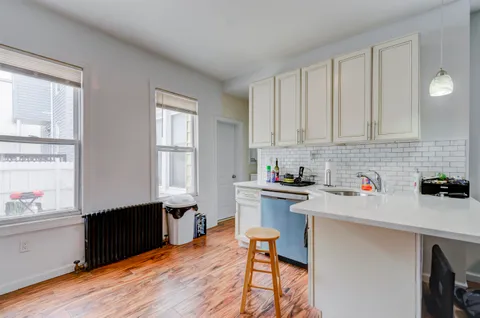 a kitchen with stainless steel appliances granite countertop a stove a sink dishwasher and a microwave with wooden floor