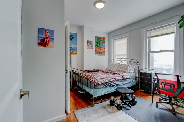 a bedroom with a bed and wooden floor