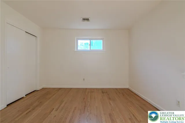 a view of a room that has wooden floor and fan