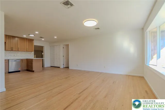 wooden floor in an empty room with a kitchen