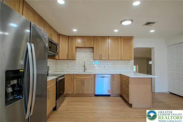 a kitchen with stainless steel appliances granite countertop a refrigerator and a sink