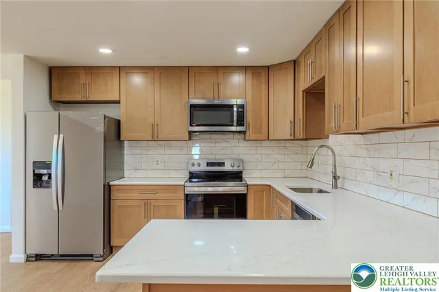 a kitchen with stainless steel appliances wooden cabinets and a sink