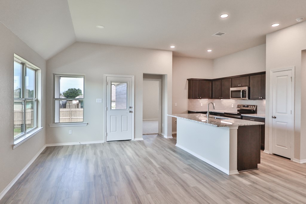 2871 Messenger Way Bryan, TX 77803 - Photo 4 of 13 a kitchen with stainless steel appliances granite countertop a stove and a refrigerator