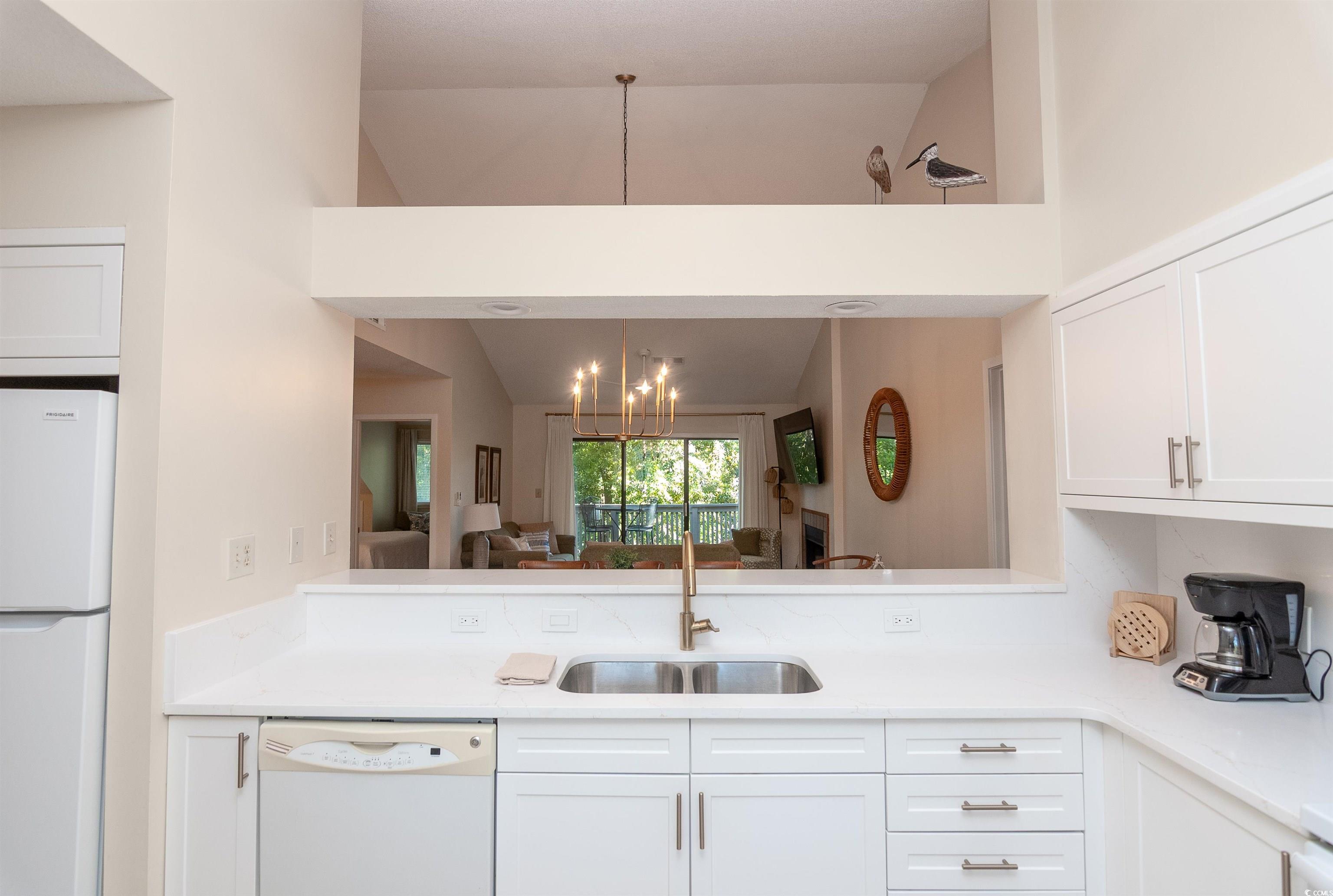 175 St Clears Way, Unit 23I Myrtle Beach, SC 29572 - Photo 39 of 39 Kitchen with white appliances, white cabinetry, a chandelier, light stone countertops, and open floor plan