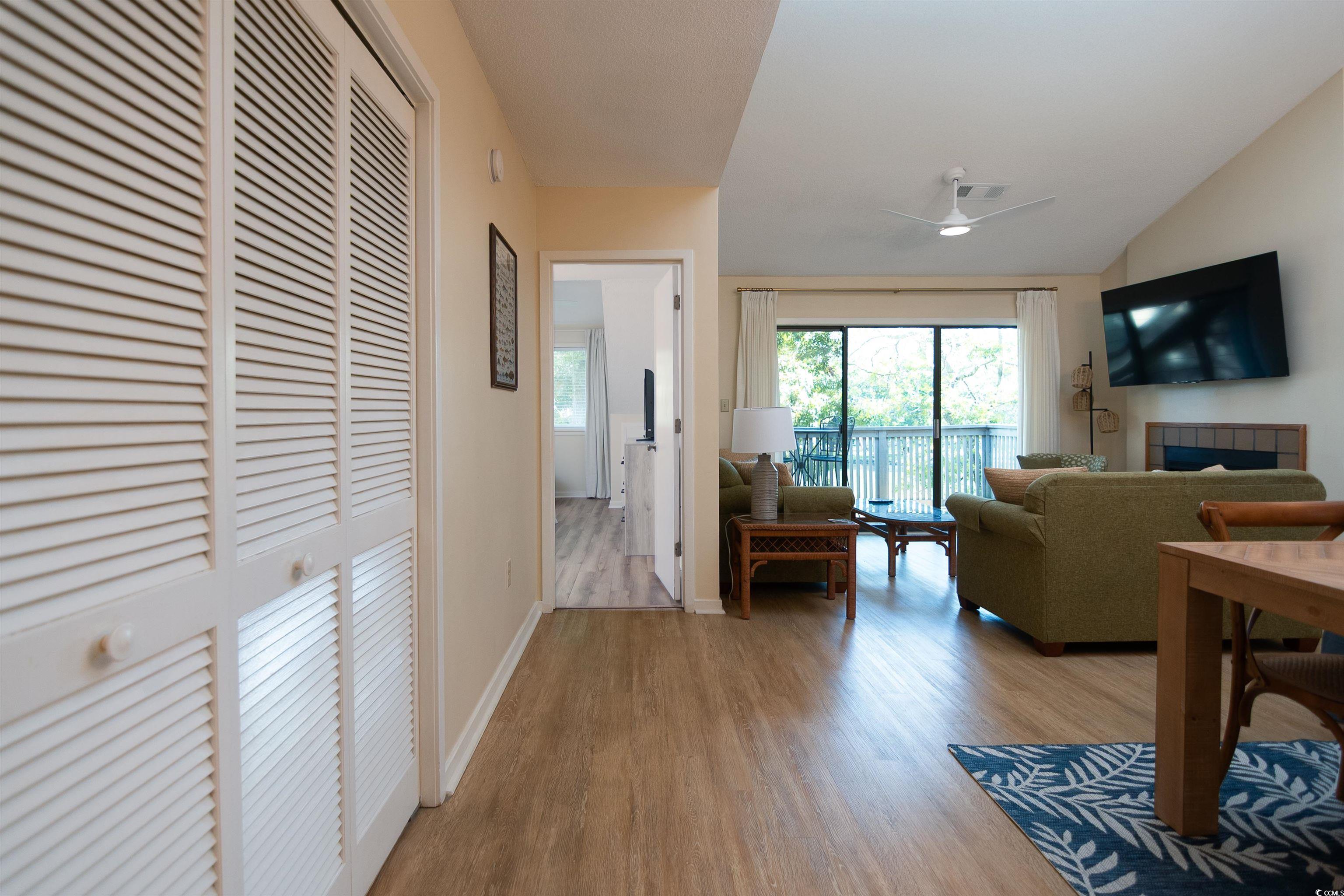 175 St Clears Way, Unit 23I Myrtle Beach, SC 29572 - Photo 5 of 39 Living area with light wood finished floors, lofted ceiling, and a tiled fireplace