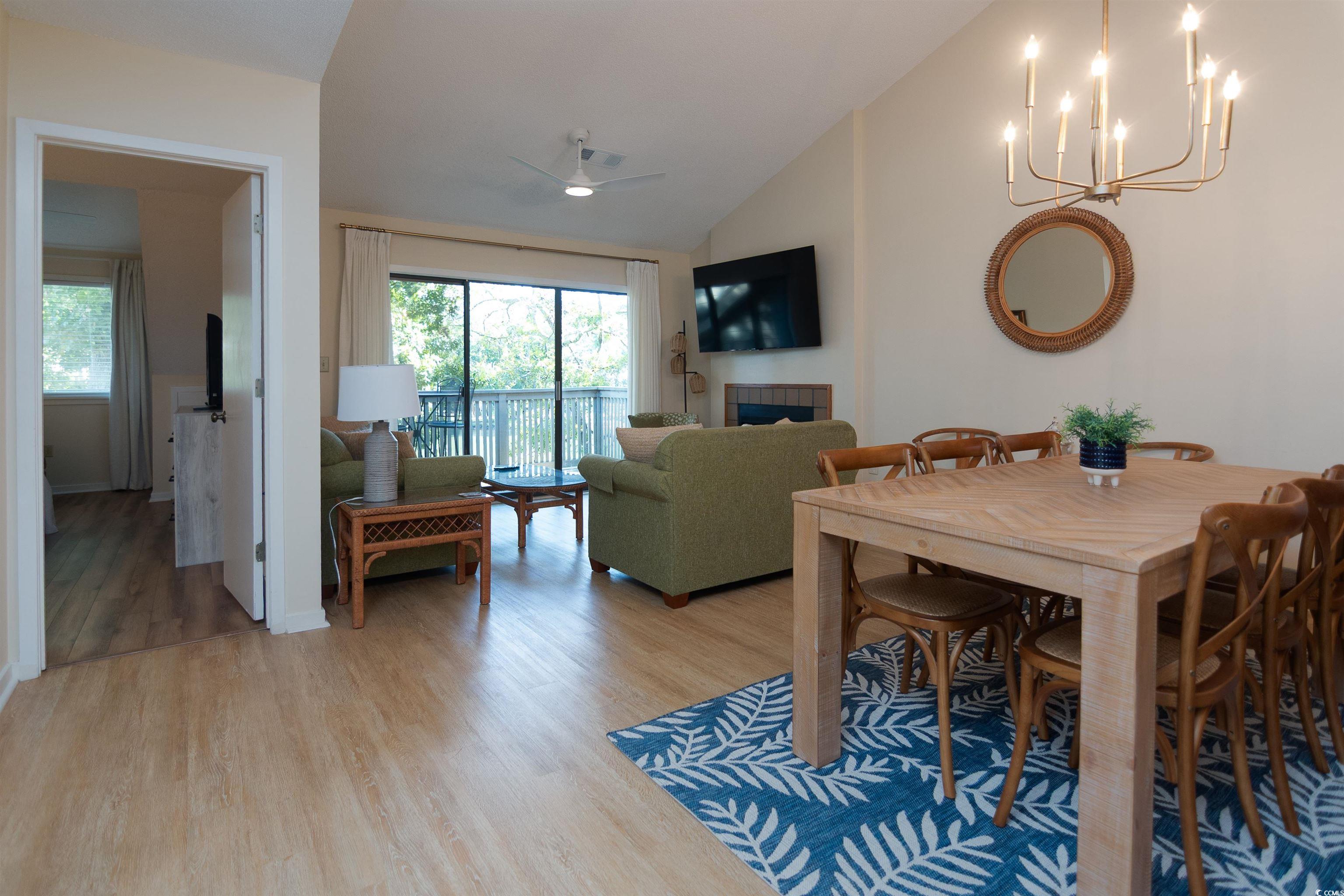175 St Clears Way, Unit 23I Myrtle Beach, SC 29572 - Photo 8 of 39 Dining space with vaulted ceiling, a tile fireplace, light wood-style flooring, and a chandelier