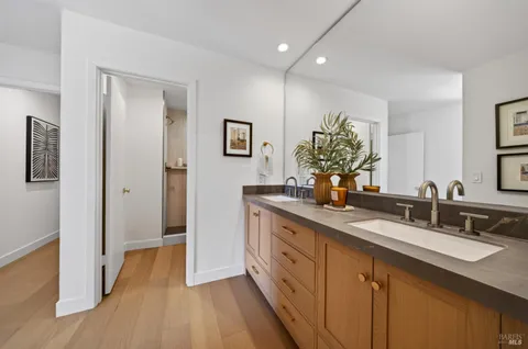 a spacious bathroom with a double vanity sink a mirror and a shower