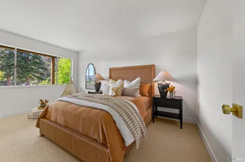a bed sitting in a bedroom next to a window