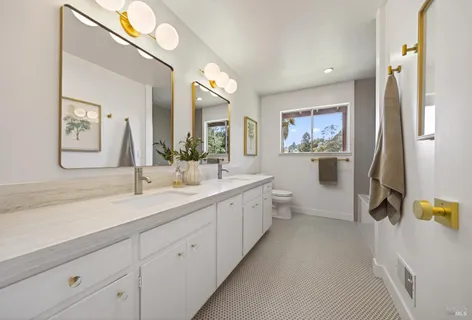 a spacious bathroom with a double vanity sink mirror and bathtub