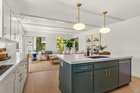 a kitchen with sink cabinets and living room view