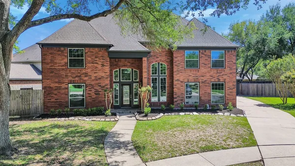 front view of a brick house with a yard