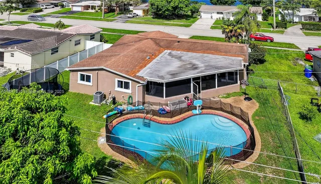 an aerial view of a house with a garden and lake view