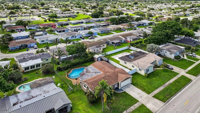 an aerial view of residential houses with outdoor space and street view