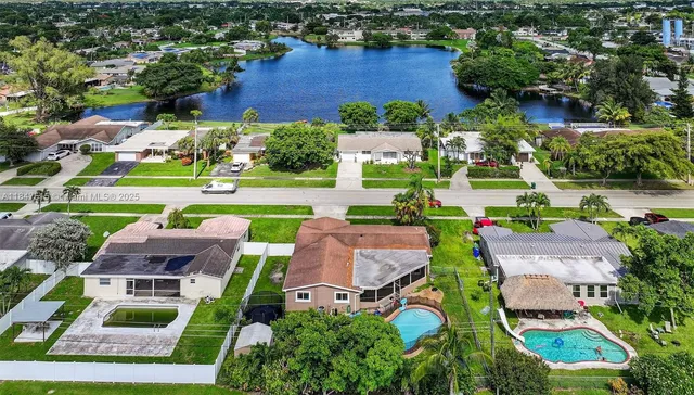 an aerial view of residential houses with outdoor space and lake view