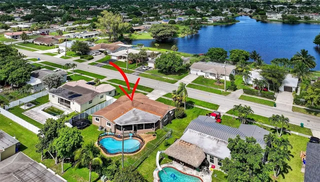 an aerial view of residential houses with outdoor space and swimming pool