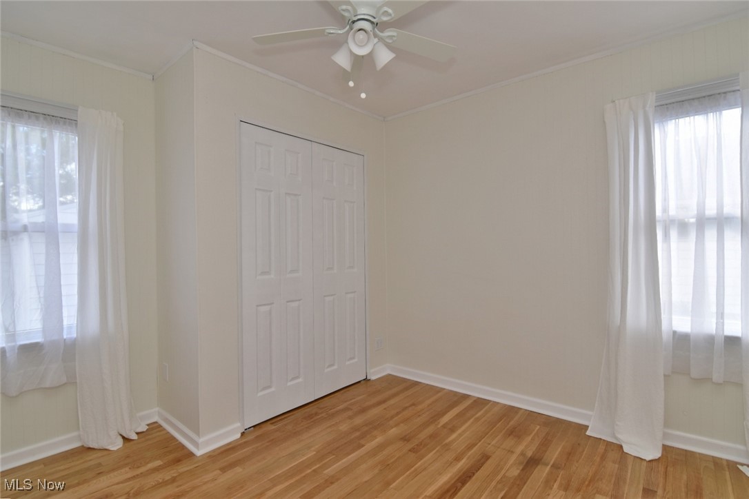 1575 Lander Road Cleveland, OH 44124 - Photo 19 of 49 Unfurnished bedroom with light wood-type flooring, crown molding, a ceiling fan, and a closet