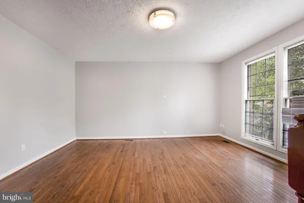 a view of a hallway with entryway and wooden floor