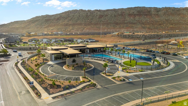 2133 Wolverine Way, Unit 2440 Washington, UT 84780 - Photo 2 of 39 Community clubhouse with multiple swimming pools, surrounded by desert landscaping and a circular drive
