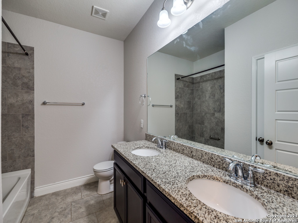 129 Aberdeen Boerne, TX 78015 - Photo 11 of 12 a bathroom with a granite countertop sink a mirror and a toilet
