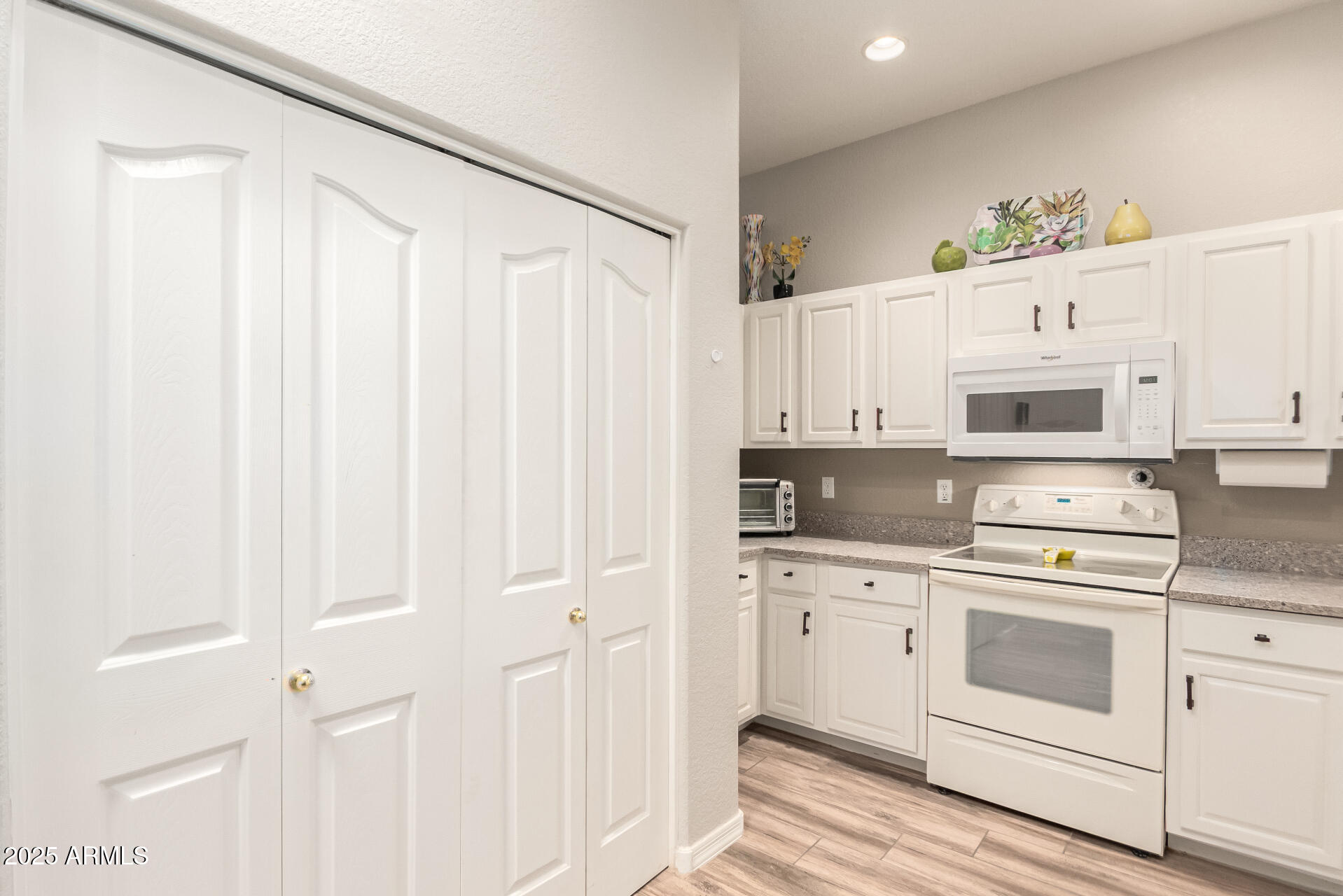 2368 West 10th Avenue Apache Junction, AZ 85120 - Photo 10 of 30 a kitchen with white cabinets and white appliances