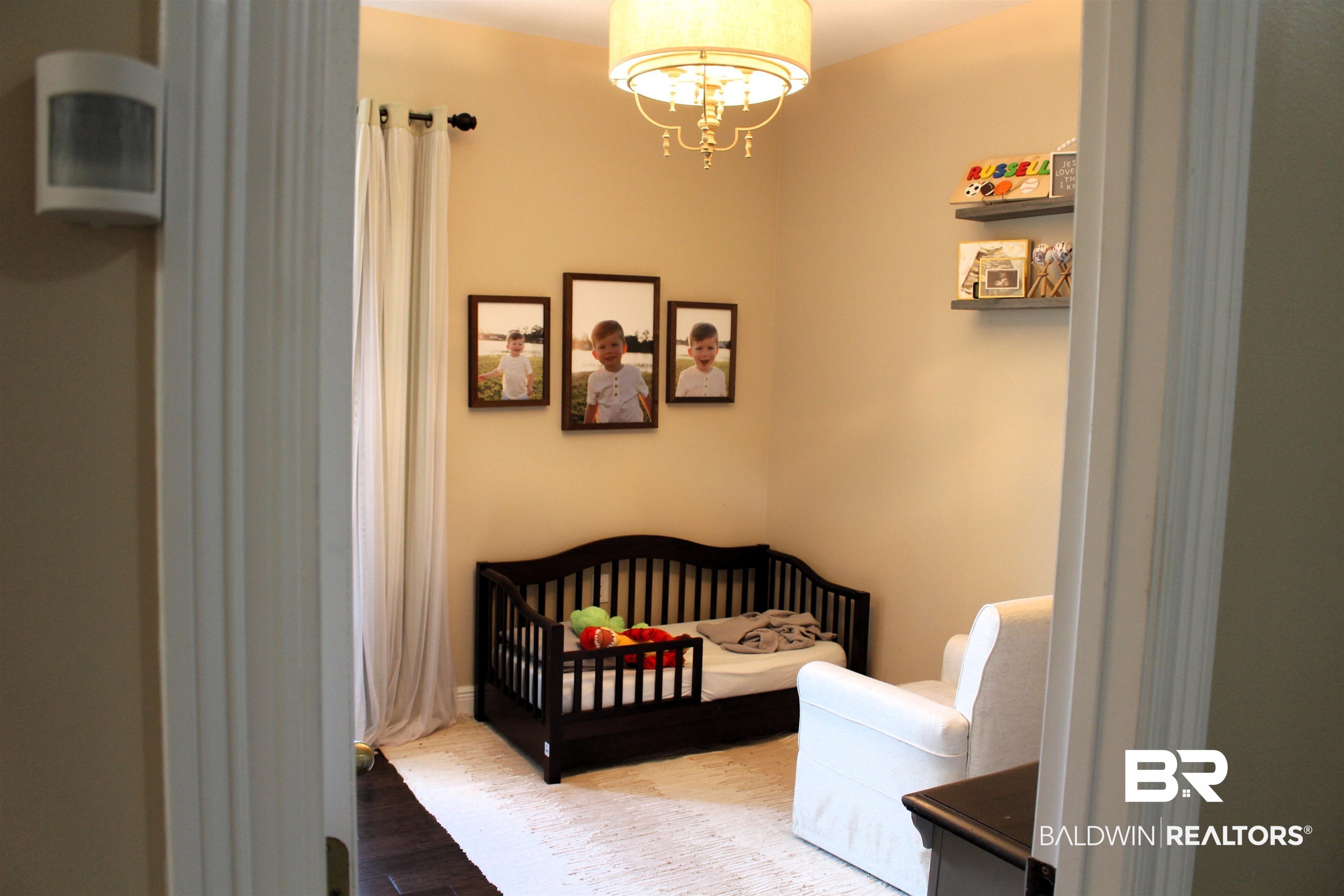 41416 Davis Duck Road Bay Minette, AL 36507 - Photo 53 of 72 Bedroom featuring a crib, wood-type flooring, and a chandelier
