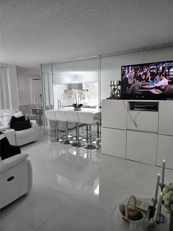 a living room with furniture and a kitchen area