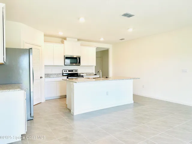 a kitchen with cabinets and a refrigerator