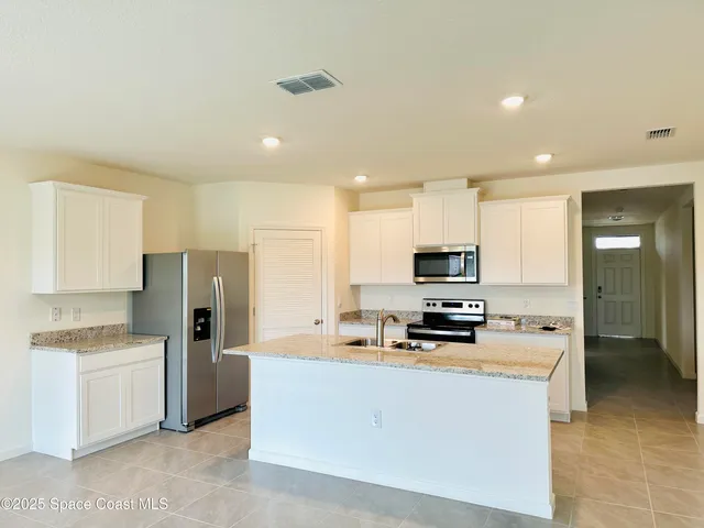 a kitchen with stainless steel appliances a refrigerator stove microwave and sink