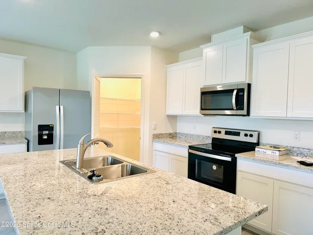 a kitchen with a stove a sink and a microwave